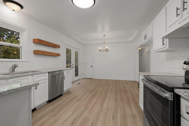 kitchen featuring light wood finished floors, a sink, stainless steel appliances, white cabinets, and under cabinet range hood