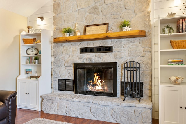 room details featuring wood finished floors, built in features, a fireplace, and visible vents