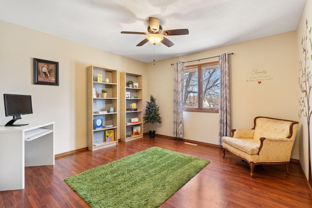 sitting room with baseboards, ceiling fan, and wood finished floors