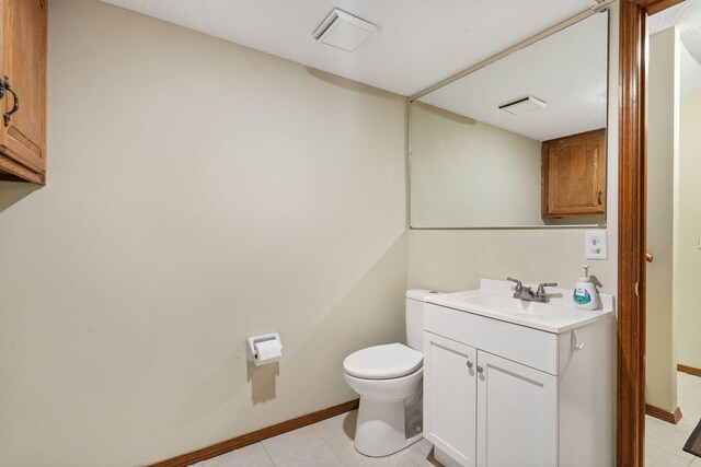 half bath with tile patterned floors, visible vents, toilet, baseboards, and vanity