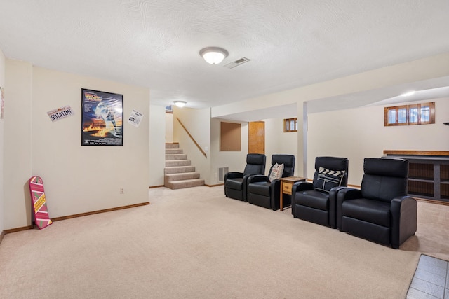 cinema room with carpet flooring, visible vents, a textured ceiling, and baseboards