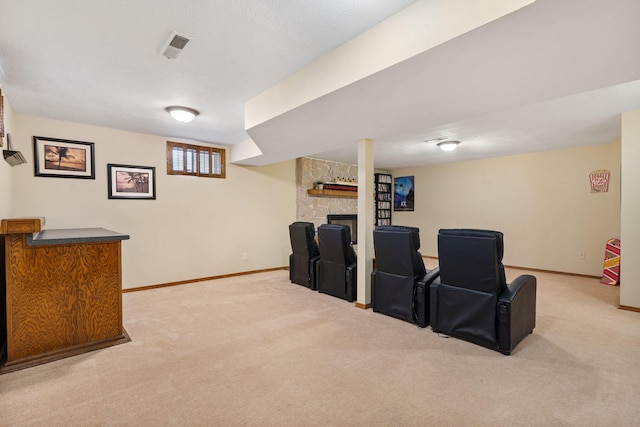 carpeted home theater with visible vents, a fireplace, and baseboards