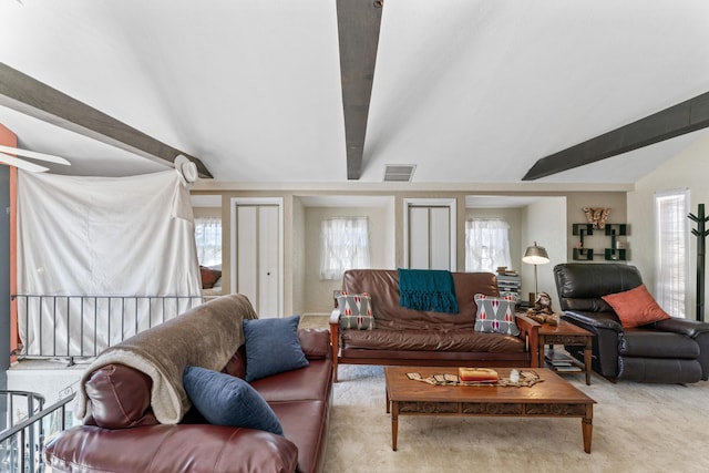 living area with lofted ceiling with beams, carpet flooring, and visible vents