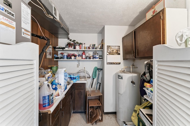 laundry area featuring water heater and a textured ceiling