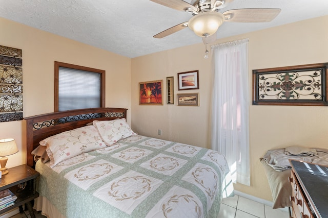 bedroom featuring a textured ceiling, ceiling fan, and tile patterned flooring