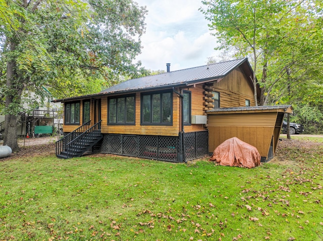 back of house featuring a yard, a sunroom, and metal roof