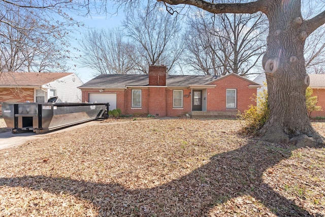 rear view of property featuring brick siding, a chimney, and a garage