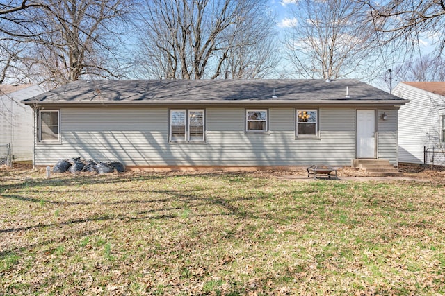 rear view of house featuring entry steps and a yard