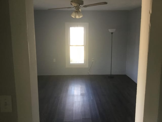 empty room featuring dark wood finished floors and a ceiling fan