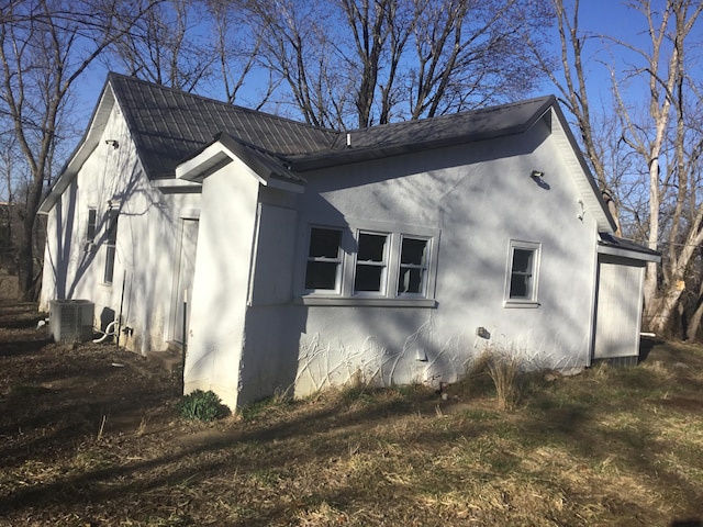 view of property exterior featuring central air condition unit, metal roof, and stucco siding