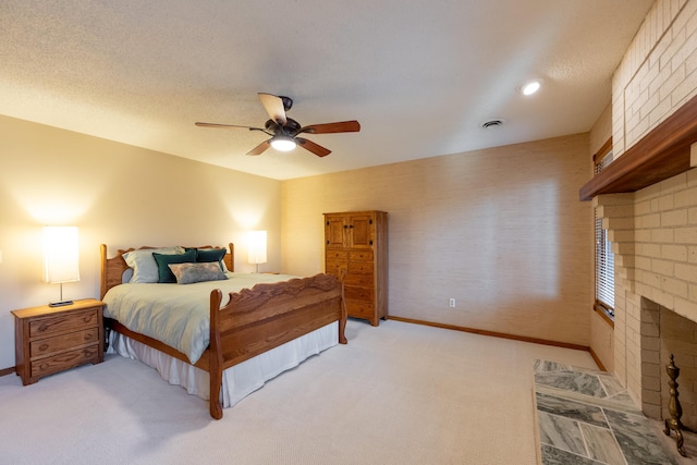 carpeted bedroom featuring a ceiling fan, baseboards, a textured ceiling, and a fireplace