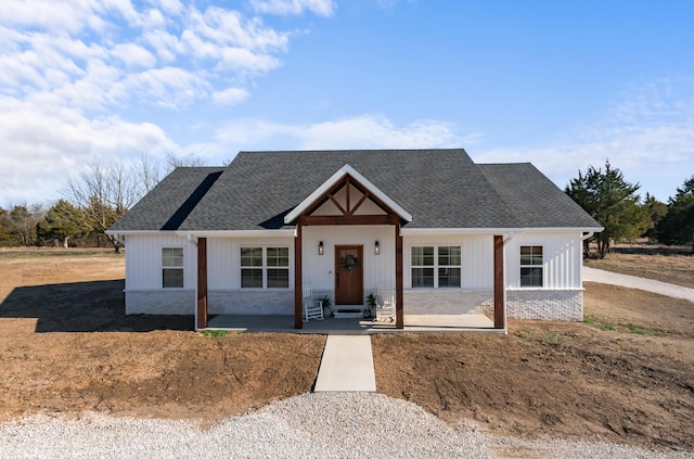 modern farmhouse featuring brick siding and roof with shingles