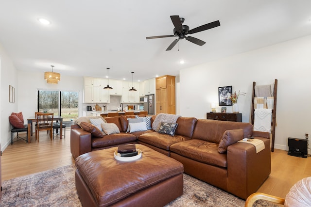 living area with recessed lighting, baseboards, and light wood finished floors