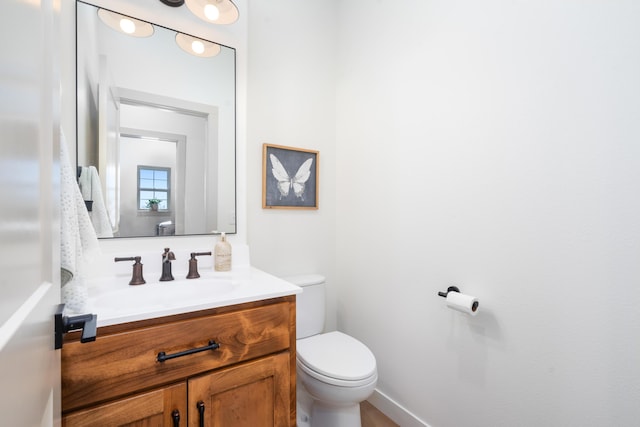 half bath featuring toilet and vanity