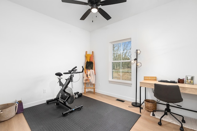 exercise area with visible vents, wood finished floors, baseboards, and ceiling fan