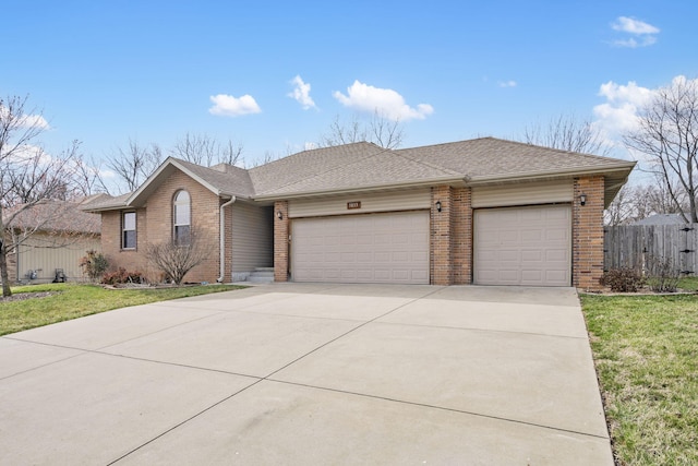 single story home with brick siding, driveway, a garage, and fence