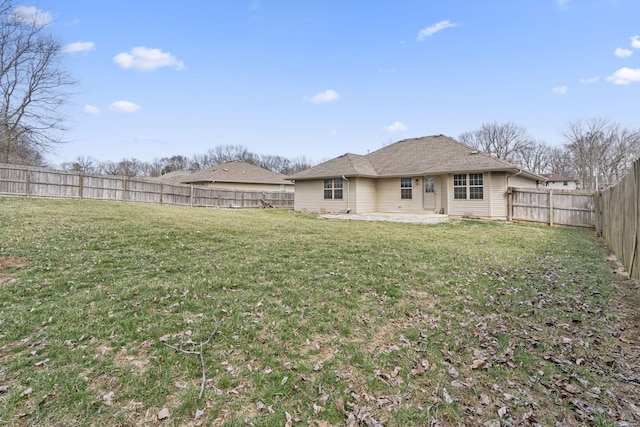 rear view of house featuring a fenced backyard, a lawn, and a patio