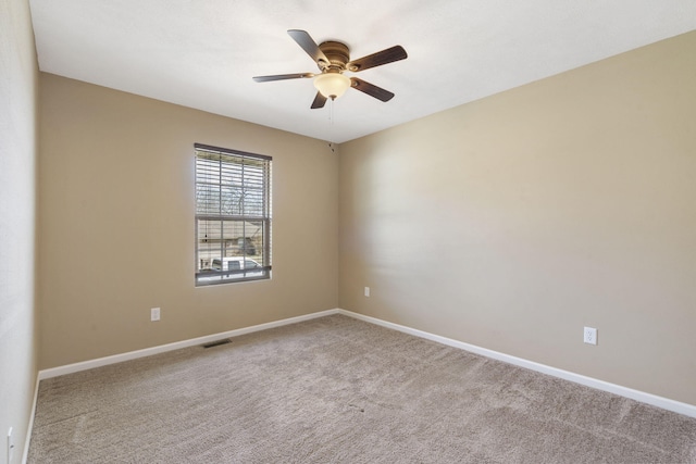 carpeted empty room with visible vents, ceiling fan, and baseboards