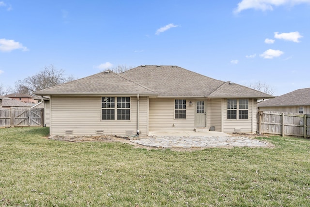 back of property with a lawn, roof with shingles, a fenced backyard, and a patio area