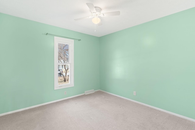 empty room featuring visible vents, carpet flooring, a ceiling fan, and baseboards