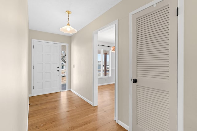 foyer entrance with baseboards and light wood-type flooring