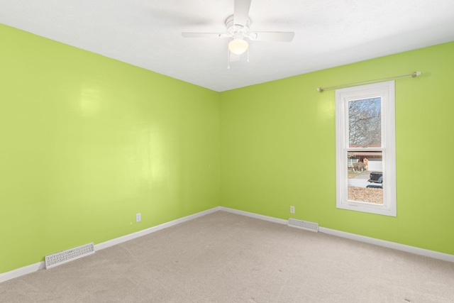 empty room with visible vents, baseboards, and light colored carpet