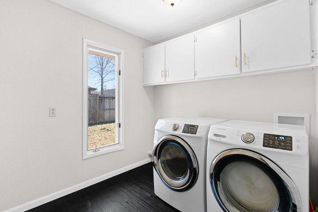 washroom featuring dark wood-style floors, cabinet space, baseboards, and separate washer and dryer