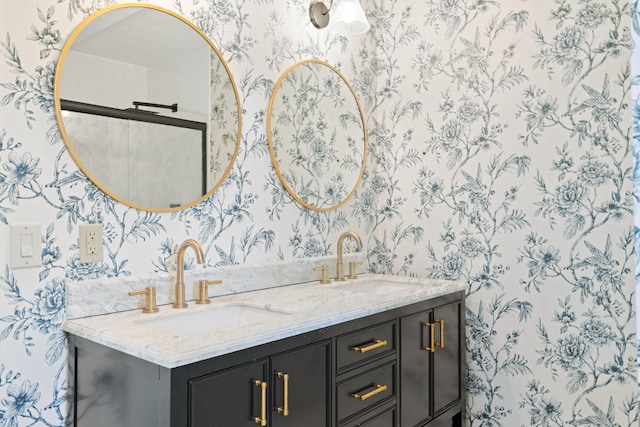 full bath with a sink, double vanity, and wallpapered walls