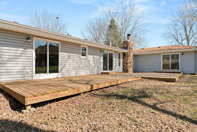 back of house with a deck and a chimney