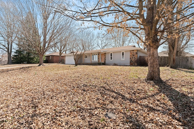 back of property with an attached garage and fence