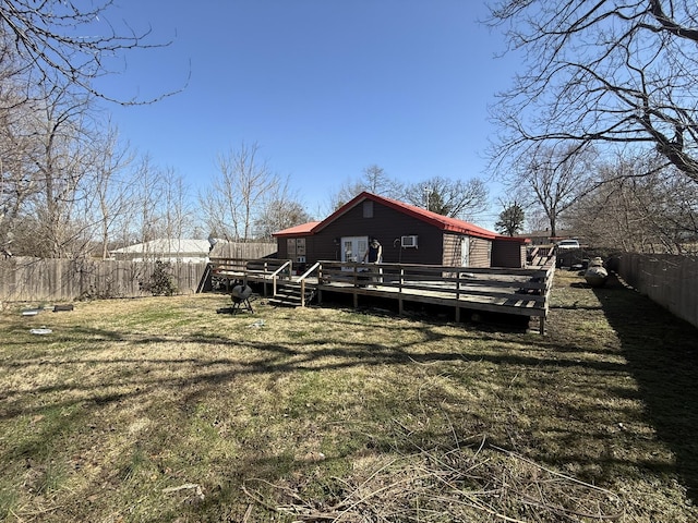 back of house with a yard, a fenced backyard, and a wooden deck