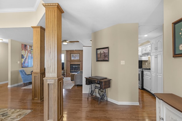 hall featuring baseboards, dark wood-type flooring, and ornate columns