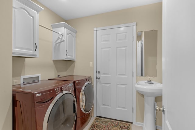 laundry room with cabinet space, independent washer and dryer, and light tile patterned flooring