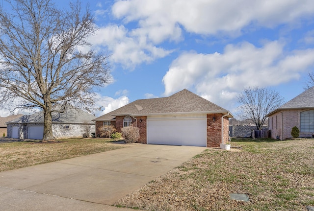 ranch-style home featuring a front yard, an attached garage, brick siding, and driveway