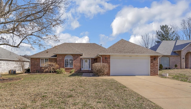 ranch-style home with a front lawn, concrete driveway, a shingled roof, a garage, and brick siding