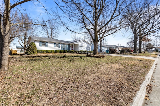 ranch-style house with concrete driveway and a front lawn