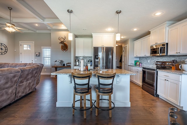 kitchen featuring stainless steel appliances, beam ceiling, dark wood-type flooring, and open floor plan