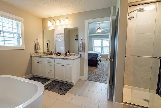 bathroom featuring double vanity, a stall shower, ensuite bath, a textured ceiling, and a sink