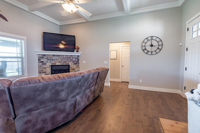 living area with beam ceiling, baseboards, a brick fireplace, ceiling fan, and dark wood-style flooring