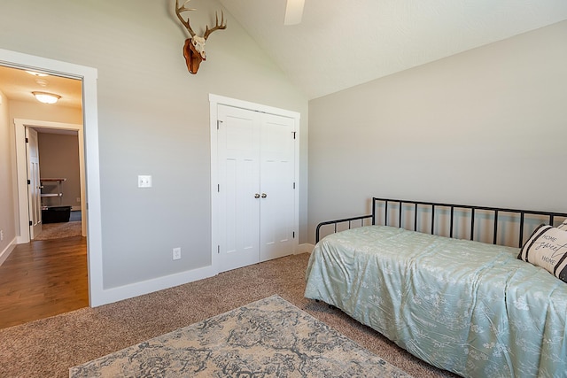 bedroom featuring ceiling fan, carpet, baseboards, vaulted ceiling, and a closet