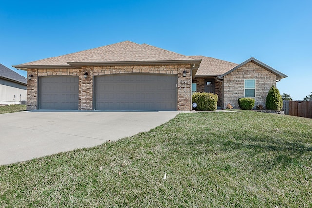 view of front of property with a shingled roof, fence, a front yard, a garage, and driveway