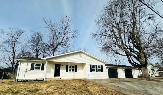 view of front of house featuring a front lawn, covered porch, a garage, and driveway