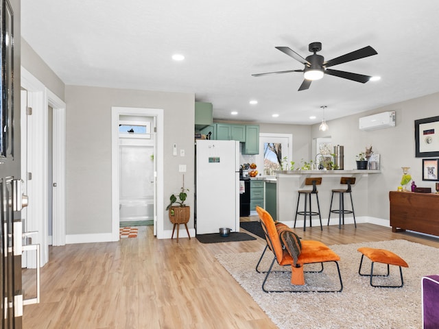 living area with a wall mounted air conditioner, baseboards, light wood-style floors, and recessed lighting