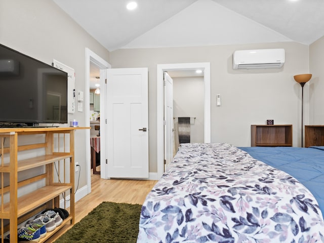 bedroom featuring lofted ceiling, a wall unit AC, and light wood finished floors