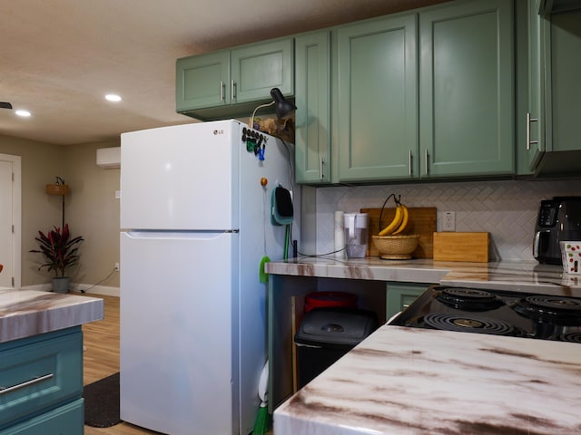 kitchen featuring backsplash, freestanding refrigerator, and green cabinetry