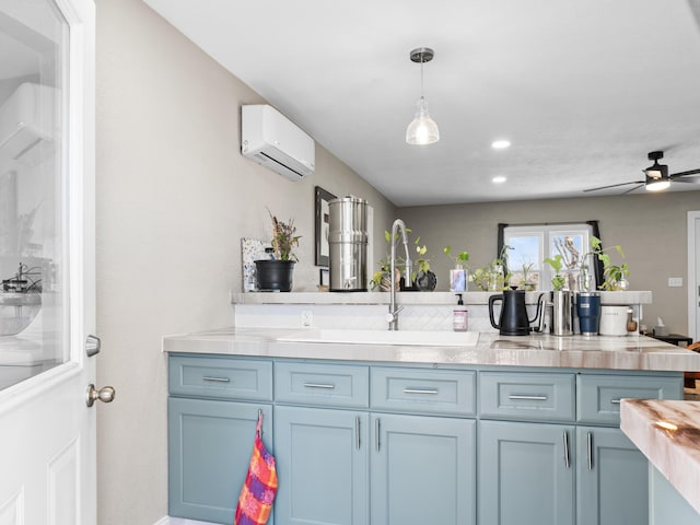 kitchen with ceiling fan, a sink, light countertops, a wall mounted air conditioner, and decorative light fixtures