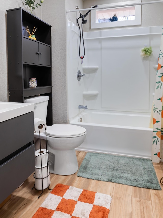 bathroom featuring vanity, toilet, wood finished floors, and shower / tub combo with curtain