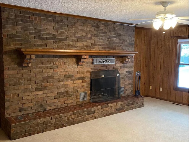 room details featuring a ceiling fan, carpet, visible vents, a fireplace, and a textured ceiling