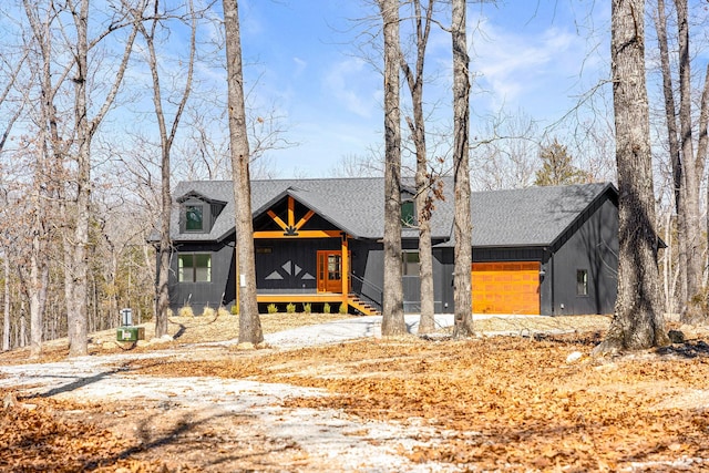 view of front facade featuring a garage, covered porch, board and batten siding, and a shingled roof