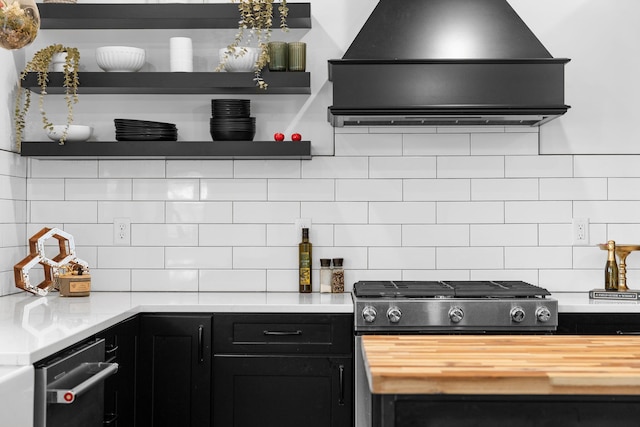 kitchen with butcher block countertops, open shelves, backsplash, extractor fan, and dark cabinets